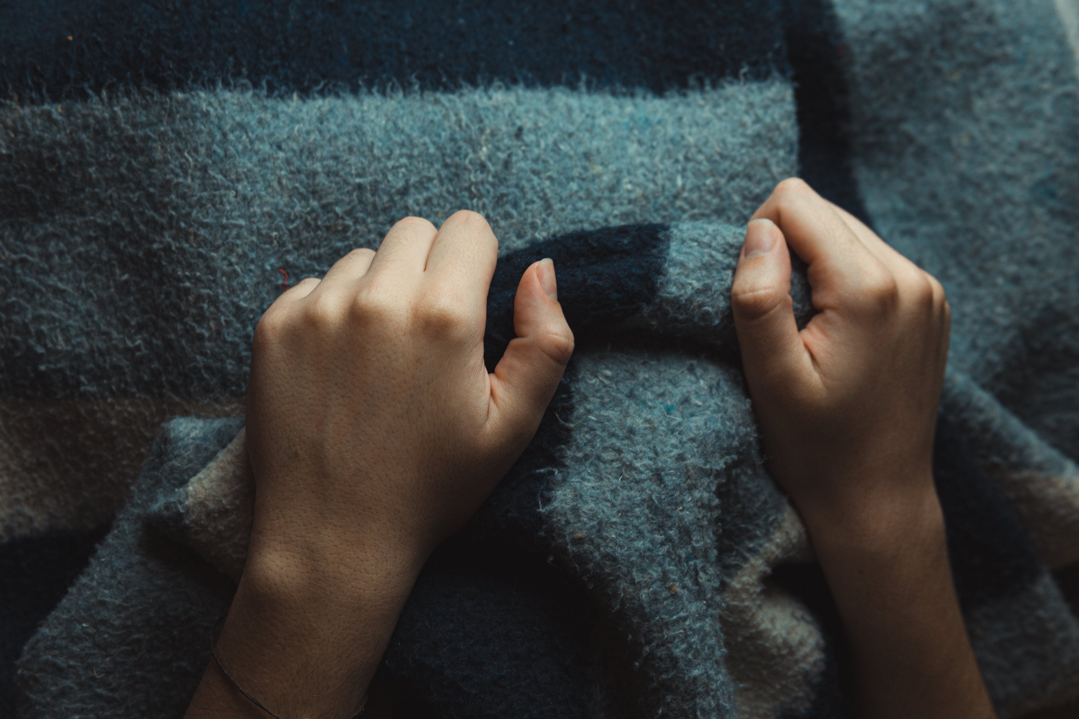 hands-grip-a-thick-wool-blanket.jpg
